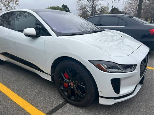 A picture of a white car with a custom caliper covers by Leprecon Plus.