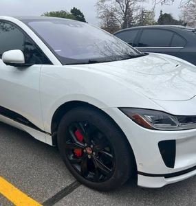 A picture of a white car with a custom caliper covers by Leprecon Plus.