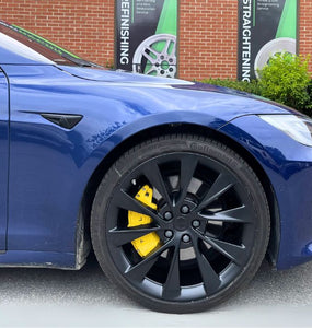 A closeup on a Tesla yellow custom caliper cover made by Leprecon Plus.