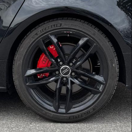 Black Audi A8 parked in front of a brick building with Leprecon branding.